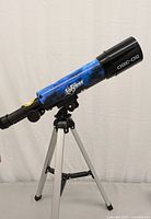 Full view of the EduScience telescope tube with starry design mounted on silver tripod stand.