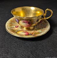 Front view of the Aynsley cup with gold interior and fruit pattern.