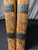 Two antique books titled Junius with full leather binding and marbled covers, showing spine with volume numbers 1 and 2.