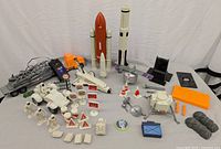Wide shot showing all NASA space toy items including shuttle, rockets, rover, astronauts, and accessories on a white backdrop.