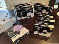 Multiple boxes of NOMA Christmas string lights including C9, C6, mini, starry lights, and floodlight bulbs revealed on a table.