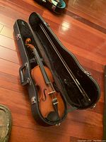 Full shot of 22 inch violin inside its hard case with bow.