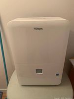 Front view of white Danby Premiere dehumidifier showing water collection window and clean exterior.