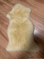 Top view of lamb fleece showing cream colored fluffy wool texture and natural sheepskin outline