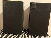 Photo showing two KEF K Series bookshelf speakers side by side, front view with grills on.