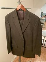 Front view of the brown men's Nautica blazer hanging on a wooden hanger.