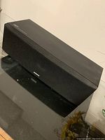 Front and top view of black Sony SS-CN3 center speaker showing fabric grille and Sony logo.