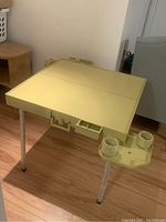 Mah Jong table fully assembled showing beige plastic surface, screw-in legs, and attached cup holders.