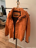 Orange Timberland jacket shell on stand, showing front and zipper areas