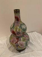 Front view of the double gourd cloisonné vase showing colorful floral enamel design and wooden base.