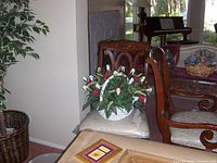 Photo showing multiple formal dining chairs with carved wooden frames and light fabric seats in a home interior.