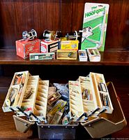 Full view of tackle box open on shelf showing reels, lures and HookOut tool