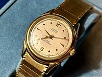 Close-up of watch face, hands, dial markings and part of expansion bracelet