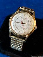 Front and angled views of vintage Crest men's wristwatch showing dial with wind indicator and automatic 17 jewel markings, gold-filled case, and textured expandable band.