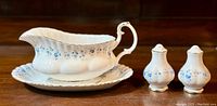 Gravy boat and under-plate with salt and pepper shakers arranged showing full set and floral pattern.