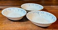 Three matching Royal Albert 'Memory Lane' serving bowls arranged on a wooden surface, showing the scalloped rims and floral pattern on the edges.
