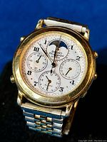 Front view of watch dial showing moon phase, subdials and bezel.