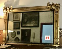 Front view showing full rectangular frame with gold leaf finish and aged mirrored glass with clouding and spots.