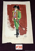 Photo showing full costume sketch on paper depicting a male character in green uniform with gold accents and black boots, on a red background.