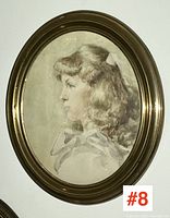Full view of the oval brass framed watercolour portrait showing the girl in profile.