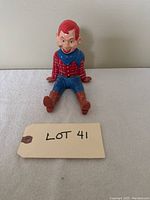 Image showing the Howdy Doody bobble head figure sitting with legs outstretched, visible red hair, checkered shirt, blue pants, blue neck scarf, brown boots, and smiling face with freckles.