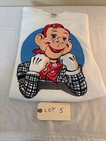 White adult extra large sweatshirt folded with front graphic print of Howdy Doody character, lying on a white towel.