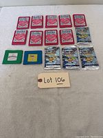 Lot contents including 12 I Love Lucy card packs, 5 Beanie Baby card packs, 2 vintage color slides all in original wrappers or mounts laid out on white surface with tag Lot 106.