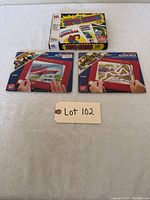 Shows all three items: Marvel card game box and two Etch A Sketch Action Packs laid flat.