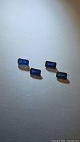 Four natural blue sapphires, octagon cut, displayed on white background highlighting shape and color