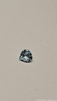 Photo showing natural pear cut sky blue topaz gemstone on plain background.