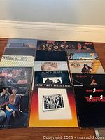 15 rock and metal LP covers arranged on floor against baseboard