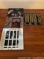 Four vinyl LP records laid out on wooden floor showing front covers. Titles include Creedence Clearwater Revival and McVicar.