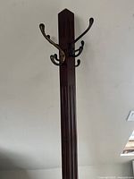 Close up showing design detail of vertical fluting on the wood post and top metal hooks