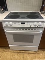 Front view of full stove showing cooktop, control panel, oven door and base drawer