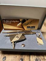 Sheaffer gold plated pen and pencil set with matching cufflinks, keychain, and tie tack in box with care guide