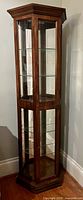 Full view tall dark wood and glass curio cabinet