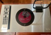 Top view with metal disc clamp containing CD, remote on left, loop antenna on right