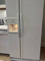 Front view of refrigerator/freezer showing dispenser and handles