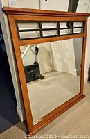 Full view of detached wooden framed mirror with grille detail at the top, showing size and frame details.