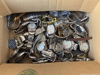 Box of mixed vintage watches showing various styles, metals, and conditions