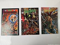 Three vintage Spawn comic books: Bloodfeud and two Violator issues displayed together on a white surface.