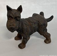 Front and side view of the cast iron Scotty dog doorstop showing texture and condition.