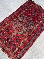 Full view of the vintage hand woven wool rug showing geometric patterns and colors