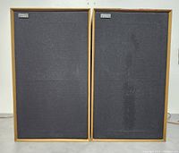 Front view of the pair of Celestion Ditton 33 speakers with black foam grilles in place, showing the front side of the cabinets.