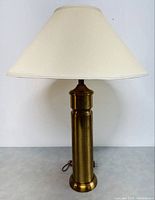 Full view of the vintage solid brass table lamp including the beige fabric lampshade, showing overall size and lamp profile.