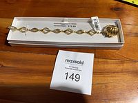 Gold plated bracelet with diamond pattern in original box and ring in front