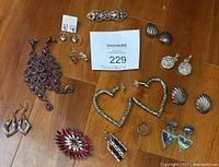 Overview of all brooches and earrings on wood floor