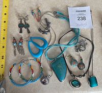 Top view of all jewelry items laid out on fabric with a measuring tape showing size reference.