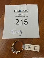 Photo of the ring with MaxSold tag labeled 'Ring' and details about cubic zirconia and ring size.