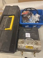 Mastercraft socket set case closed, black plastic toolbox with yellow handle, metal toolbox, and blue plastic bin with tools and hardware